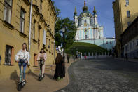 Two women ride scooters in downtown Kyiv, Ukraine, Monday, May 23, 2022. (AP Photo/Natacha Pisarenko)