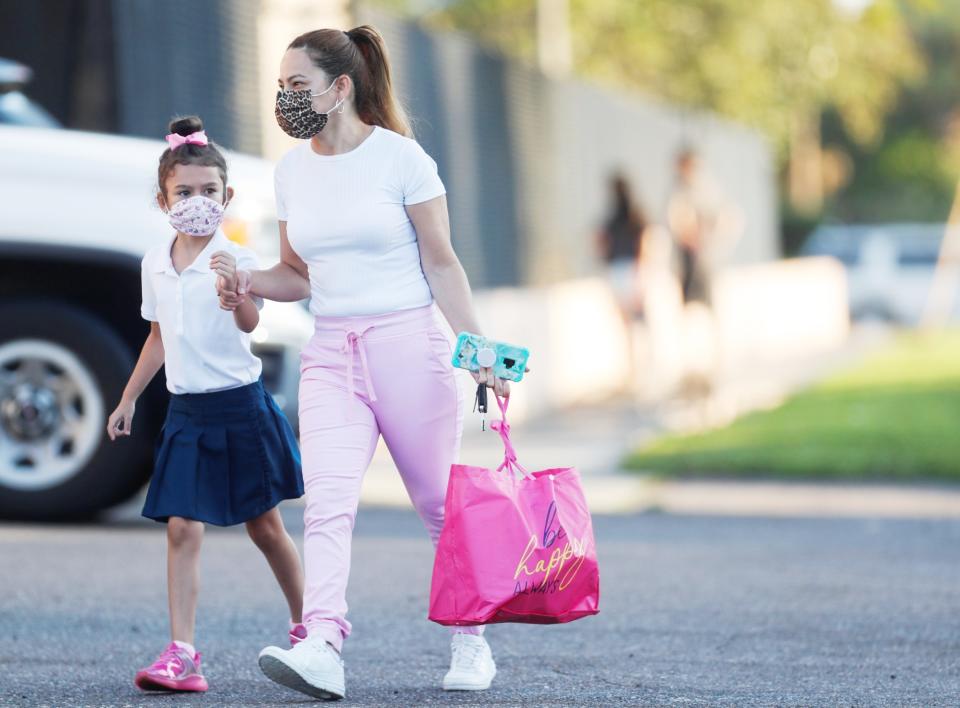 A mother walks her daughter on the first day of school, amid the coronavirus pandemic, at West Tampa Elementary School in Tampa, Florida, August 10, 2021. (REUTERS/Octavio Jones)