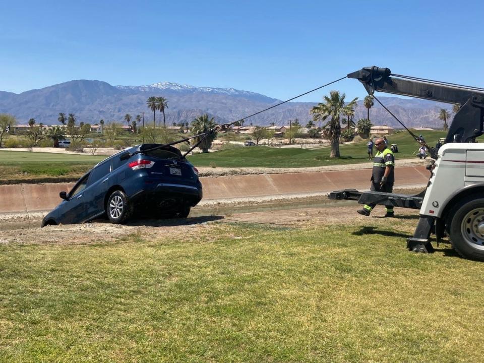 A Nissan Pathfinder is pulled from the water after it drove into the All-American Canal at Terra Lago Golf Resort in Indio. The driver was rescued by a golfer and a golf official who dove into the canal.