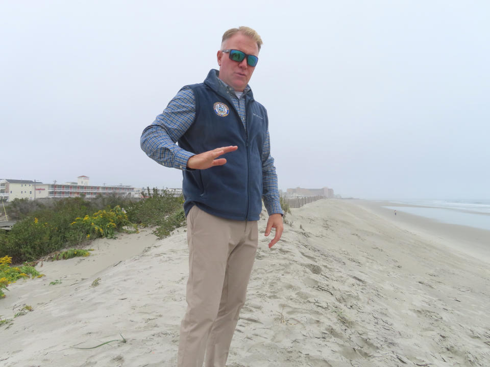 Mayor Patrick Rosenello stands atop a recently repaired dune in North Wildwood, N.J., on Tuesday, Oct. 25, 2022. The town used bulldozers to push sand back into piles to repair severe erosion from recent storms, despite a directive from state environmental officials not to do the work until the proper studies and planning took place. (AP Photo/Wayne Parry)