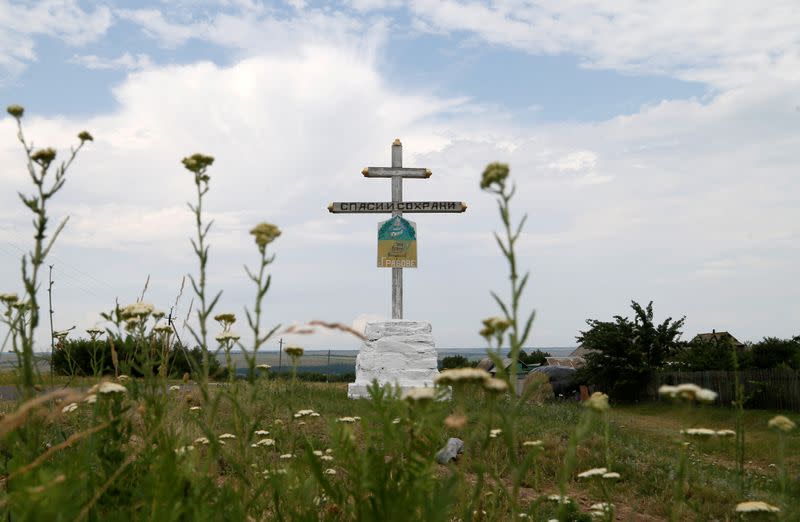 FILE PHOTO: A view shows a cross near the crash site of Malaysia Airlines Flight MH17 plane outside Hrabove
