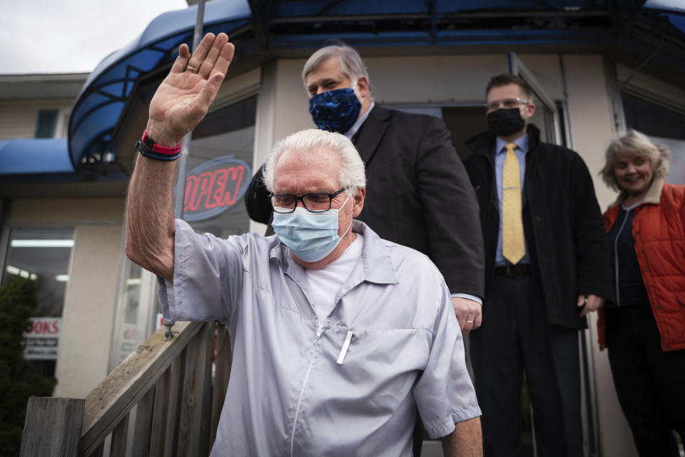 Karl Manke, 77, waves to people gathered just before a press conference on Monday, May 11, 2020 at Karl Manke's Beauty & Barber Shop in Owosso, Mich. Manke has defied the governor's order not to conduct business. (Sarahbeth Maney/The Flint Journal via AP)