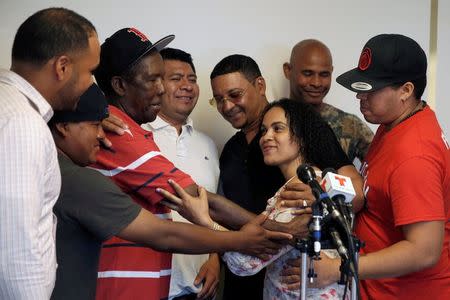 A group of immigrant car wash workers embrace workplace justice worker Modesta Toribio at a news conference, where 18 workers received the final part of a $1.6 million federal court settlement for unpaid wages after a five-year case against four car washes in New York City and New Jersey, in Manhattan, New York City, U.S., June 21, 2016. REUTERS/Mike Segar