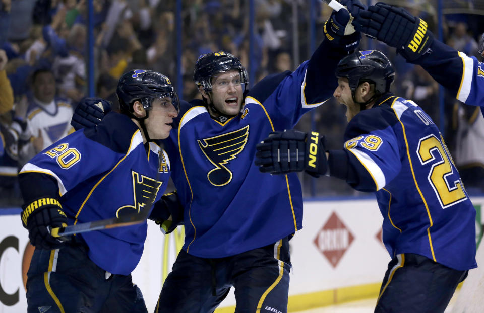 St. Louis Blues' Alexander Steen, left, is congratulated by teammates David Backes, center, and Steve Ott, right, after scoring the game-winning goal during the third overtime in Game 1 of a first-round NHL hockey Stanley Cup playoff series against the Chicago Blackhawks Thursday, April 17, 2014, in St. Louis. The Blues won 4-3 in triple overtime. (AP Photo/Jeff Roberson)