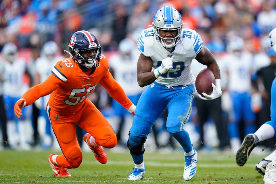 Detroit Lions running back Kerryon Johnson (33) runs as Denver Broncos outside linebacker Von Miller (58) pursues during the second half on Dec. 22, 2019, in Denver.