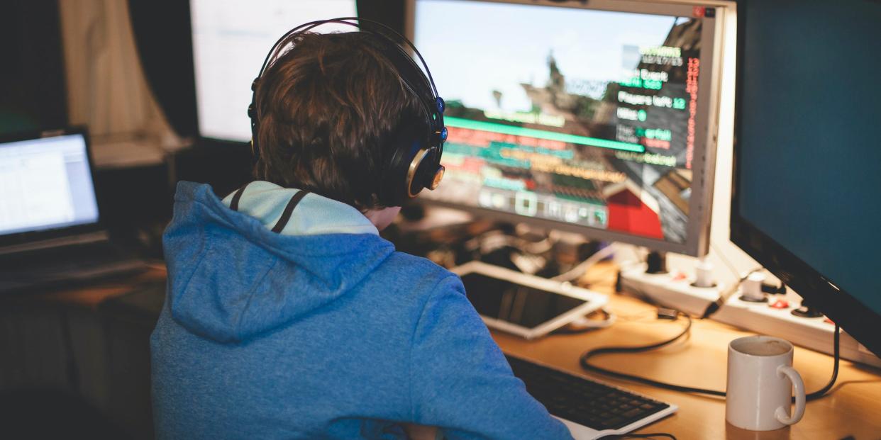boy gaming video games on computer headphones