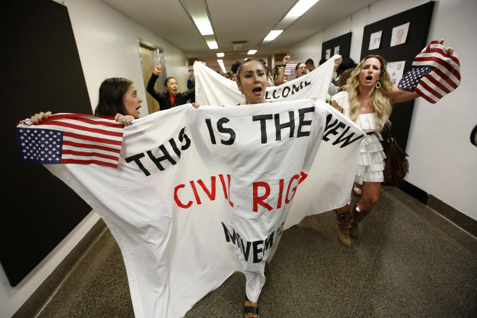 Heidi Munoz Gleisner, left, Denise Aguilar, center and Tara Thornton, right, lead a march through the Capitol in protest of the state Legislature's passage of a measure to crack down on doctors who sell fraudulent medical exemptions for vaccinations, in Sacramento, Calif., Wednesday, Sept. 4, 2019. Lawmakers sent the bill to Newsom on Wednesday but he said he wants last-minute changes. (AP Photo/Rich Pedroncelli)