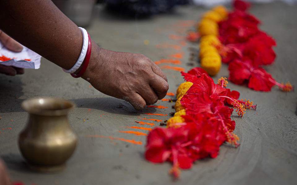 A Hindu woman performs rituals during a prayer ceremony to rid the world of coronavirus, on the banks of the river Brahmaputra in Gauhati, India, Friday, June 5, 2020. (AP Photo/Anupam Nath)