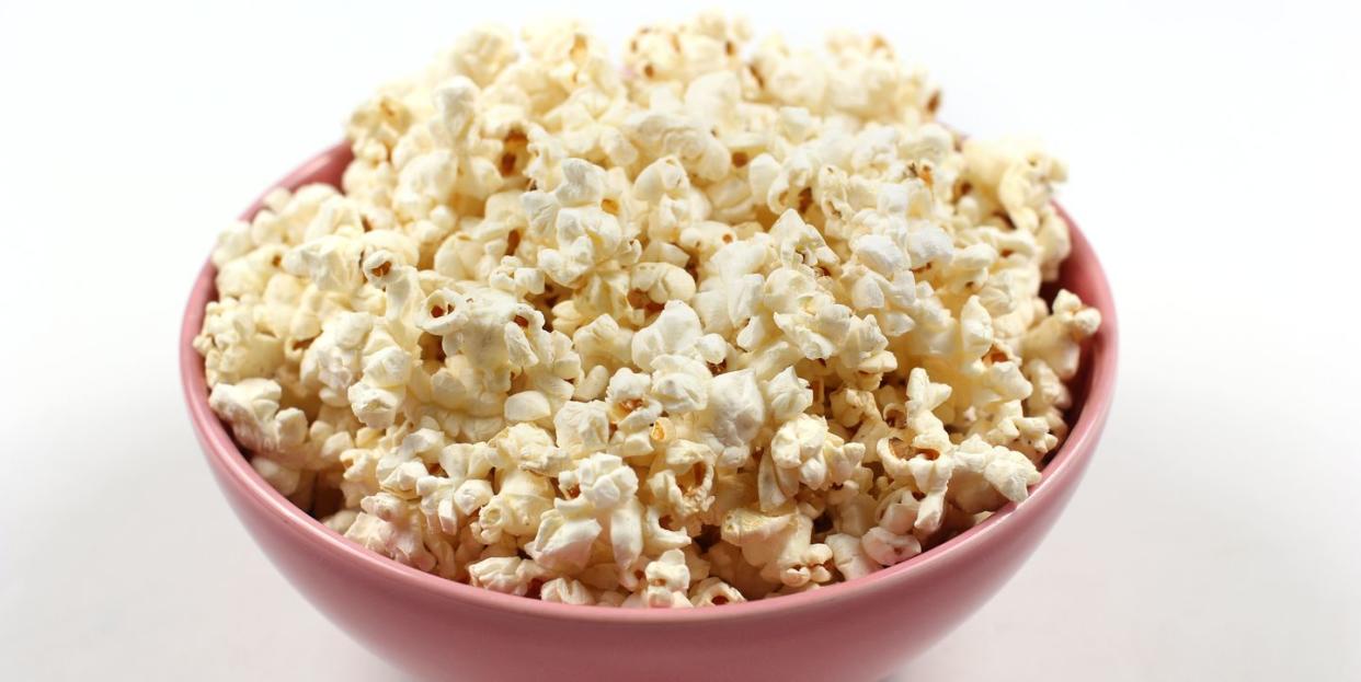 close up of popcorn in bowl on white background