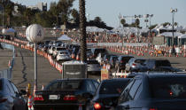 Los Angeles residents wait in line in their cars during the early morning to receive a covid-19 vaccine at Dodger Stadium, in Los Angeles on Tuesday, Jan. 26, 2021. California is revamping its vaccine delivery system to give the state more control over who gets the shots following intense criticism of a slow and scattered rollout by counties. (AP Photo/Richard Vogel)