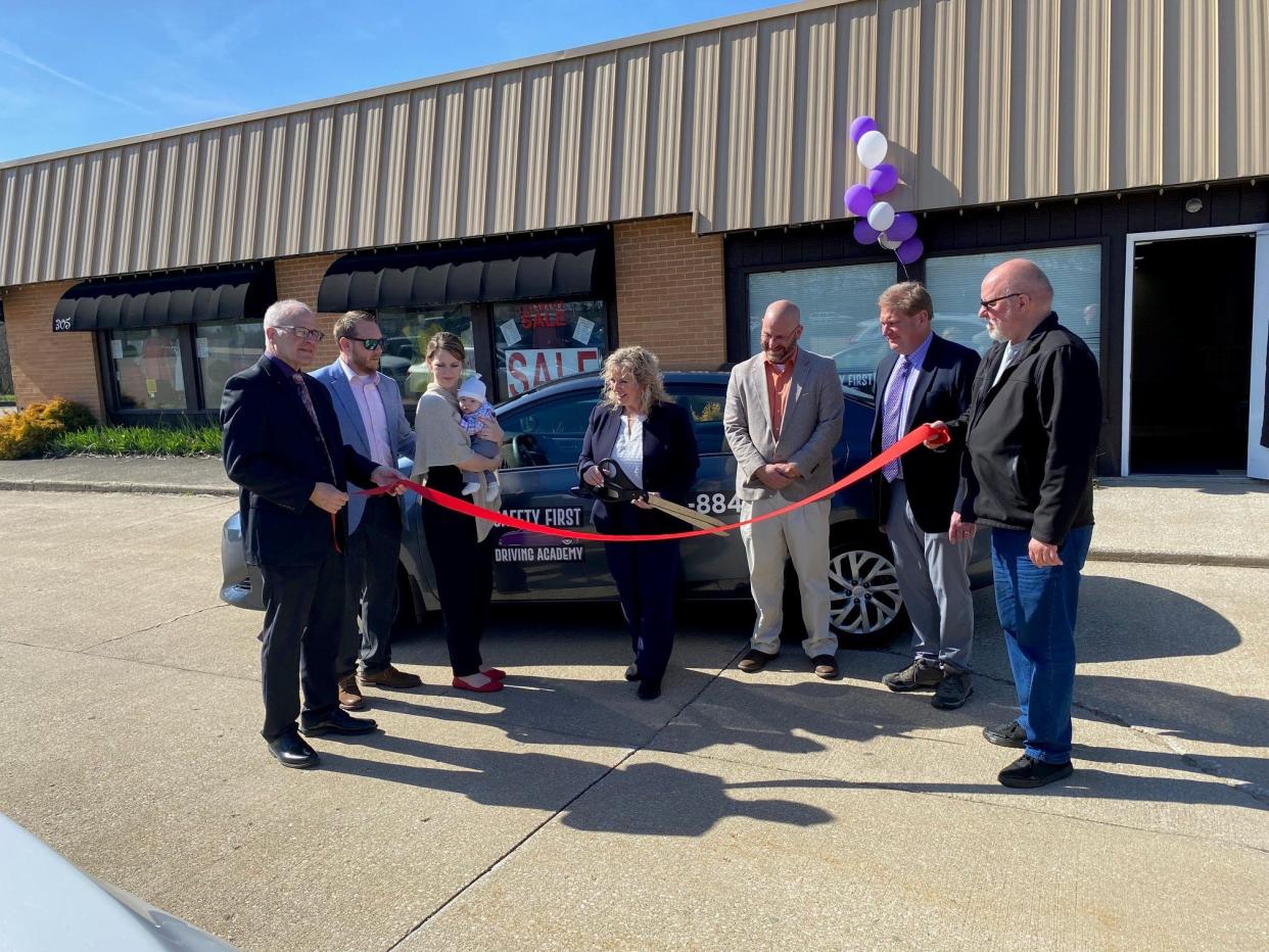 Celebrating the Monday afternoon ribbon-cutting of a new Lexington business, Safety First Driving School, are, from left, Lexington Mayor Brian White; Ryan and Nicole Anschutz and son Noah; Lori Cope, owner and instructor; Lexington council members Adam Gongwer and Bob Jarvis; and Harold Cope, Lori's husband and co-owner. The business is at 305 E. Main St.,