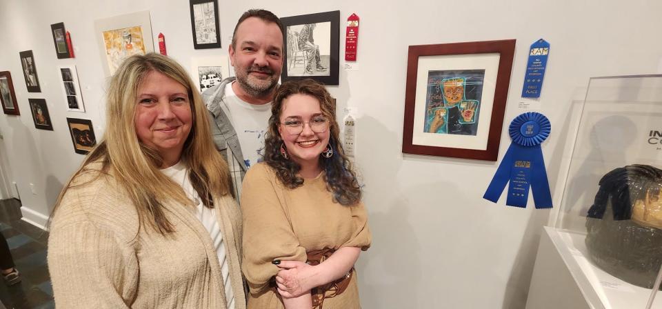 Holly Hancock (right), Northeastern High School junior, stands with parents Joanie and Steve Hancock next to her piece "Untitled." Hancock won first place in the Mixed Media category and Best of Show for the 18th Annual All Wayne County High School Art Exhibition at the Richmond Art Museum, unveiled Saturday April 20, 2024.