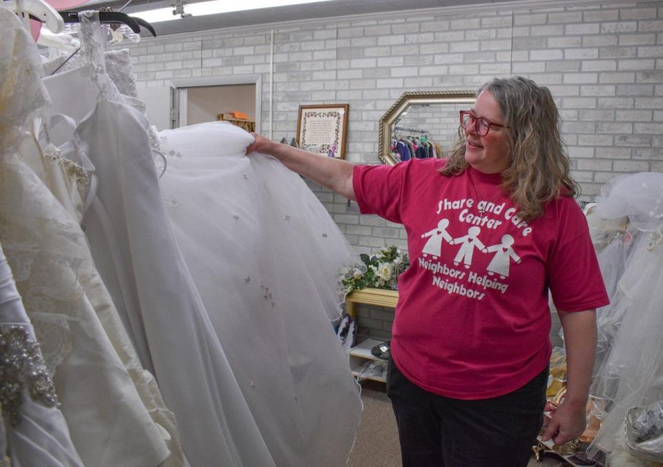 Twice Blessed Executive Director Lynette Kirsch looks through the like-new wedding dresses available at the shop.