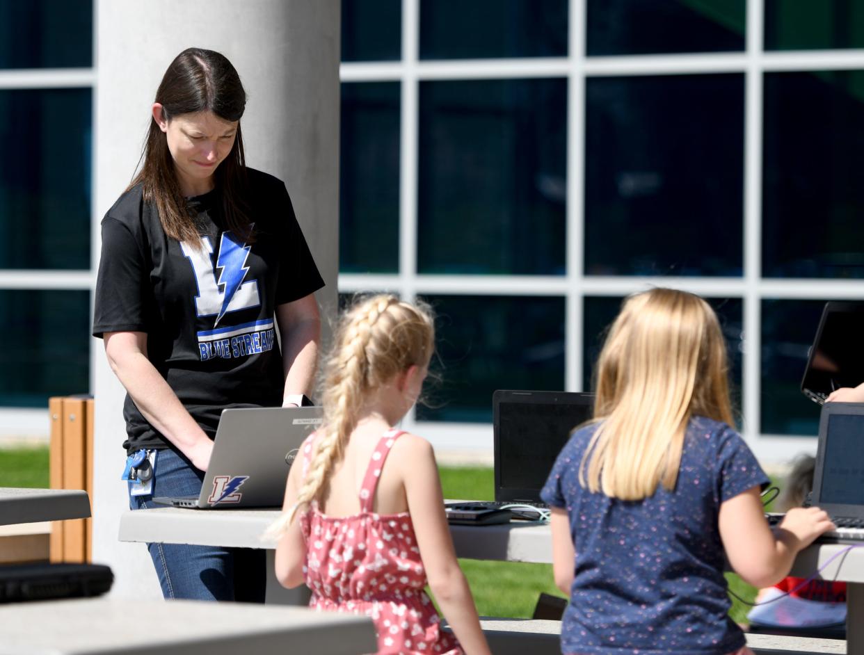 Third grade music  teacher Danielle Shaub works with students learning piano on a  keyboard on a warm day at  Lake Elementary School.  Friday,  April 14, 2023.