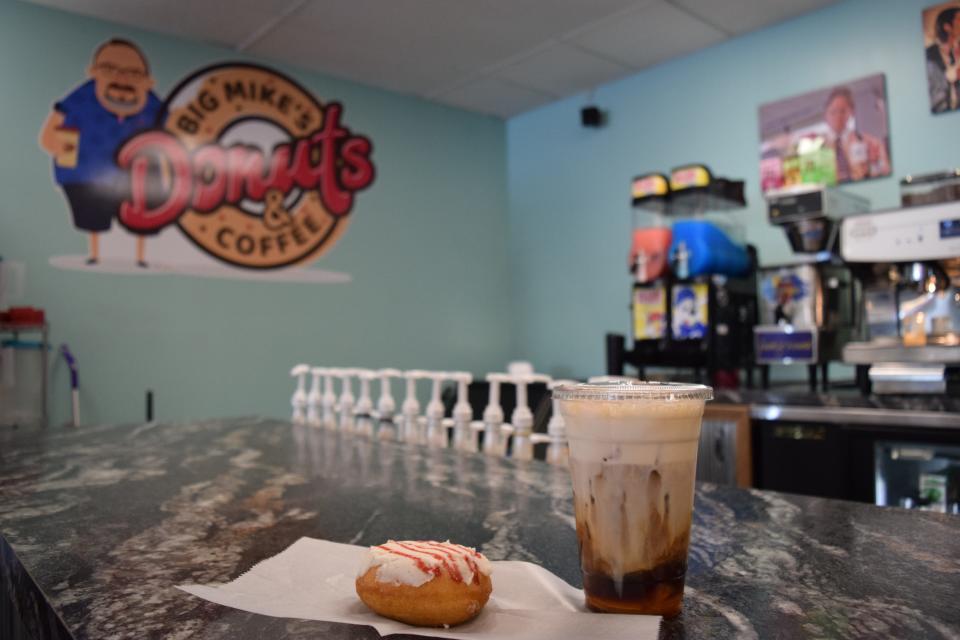 A strawberry shortcake doughnut and Cinnamon Toast Crunch latte sit on the counter at Big Mike's Donuts and Coffee.