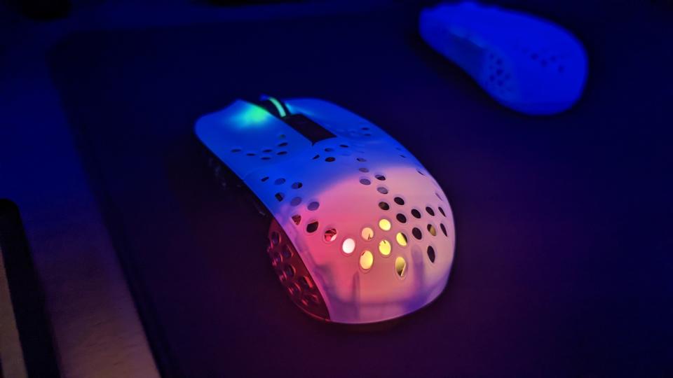 A black and white MZ1 Wireless mouse with its lights turned on on a black mousepad. (Photo: Yahoo Gaming SEA)