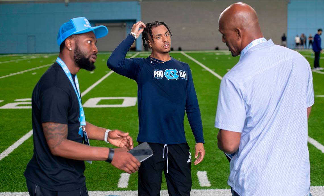 North Carolina’s Josh Downs talks with his father Gary Downs, right and trainer Stephon Brown during the NFL Pro Day on Monday, March 27, 2023 in Chapel Hill, N.C.