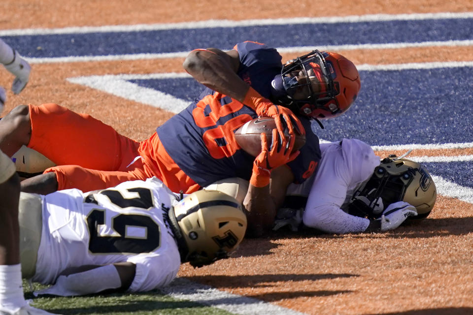 Illinois tight end Daniel Imatorbhebhe (88) falls into the end zone for a touchdown as Purdue cornerback Simeon Smiley, left, and DJ Johnson defend during the second half of an NCAA college football game Saturday, Oct. 31, 2020, in Champaign, Ill. (AP Photo/Charles Rex Arbogast)