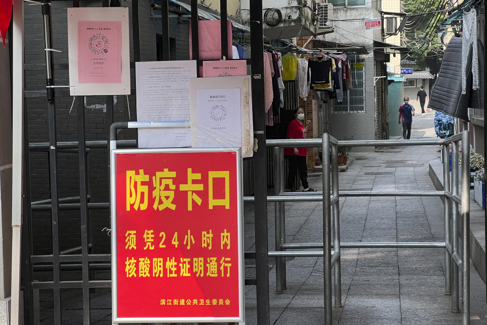 A sign reads "Pandemic checkpoint, 24-hours negative COVID test required' at a residential community in the Haizhu district in Guangzhou in southern China's Guangdong province Friday, Nov. 11, 2022. As the country reported 10,729 new COVID cases on Friday, more than 5 million people were under lockdown in the southern manufacturing hub Guangzhou and the western megacity Chongqing. (AP Photo)