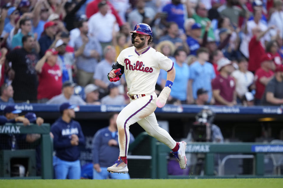 Philadelphia Phillies' Bryce Harper scores on a double by J.T. Realmuto during the ninth inning of a baseball game against the Toronto Blue Jays, Wednesday, May 10, 2023, in Philadelphia. (AP Photo/Matt Slocum)