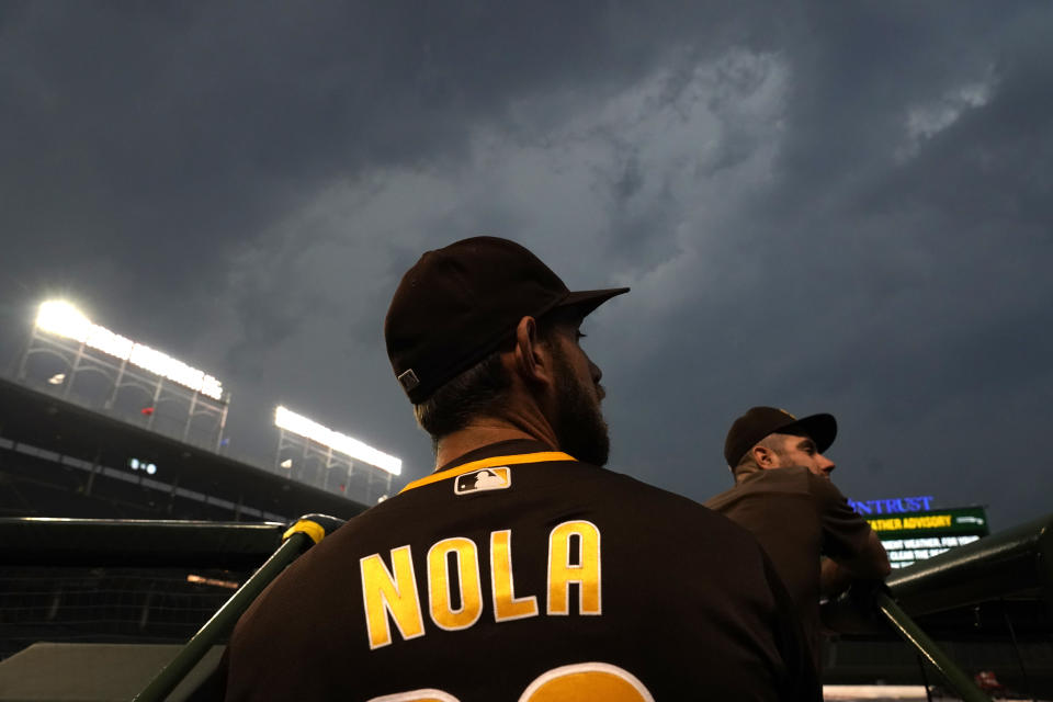 San Diego Padres catcher Austin Nola looks out from the dugout as a storm that has spawned a tornado warning descends upon Wrigley Field before a baseball game between the Chicago Cubs and the Padres Monday, June 13, 2022, in Chicago. (AP Photo/Charles Rex Arbogast)