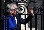 Theresa May stands next to her husband Philip as he waves outside Downing Street, on her last day in office as Britain's Prime Minister, in London