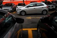 A man drives a Chevrolet Onix hatchback at the car park of a newly opened Movida car rental service store specialized in ride-hailing companies in Sao Caetano do Sul