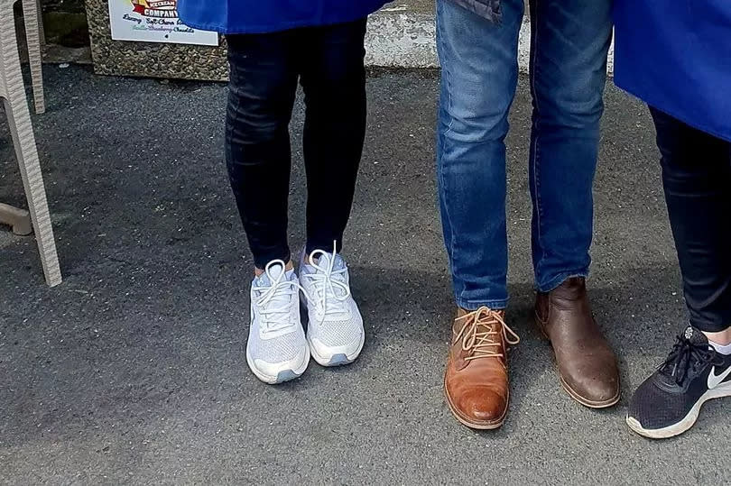 The 75-year-old TV presenter posed for a photo with the owners of the café - but his "odd" shoe choice stood out.