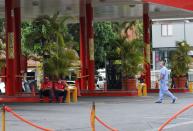 A doctor walks near a closed gas station during the nationwide quarantine due to the coronavirus disease (COVID-19) outbreak, in Caracas