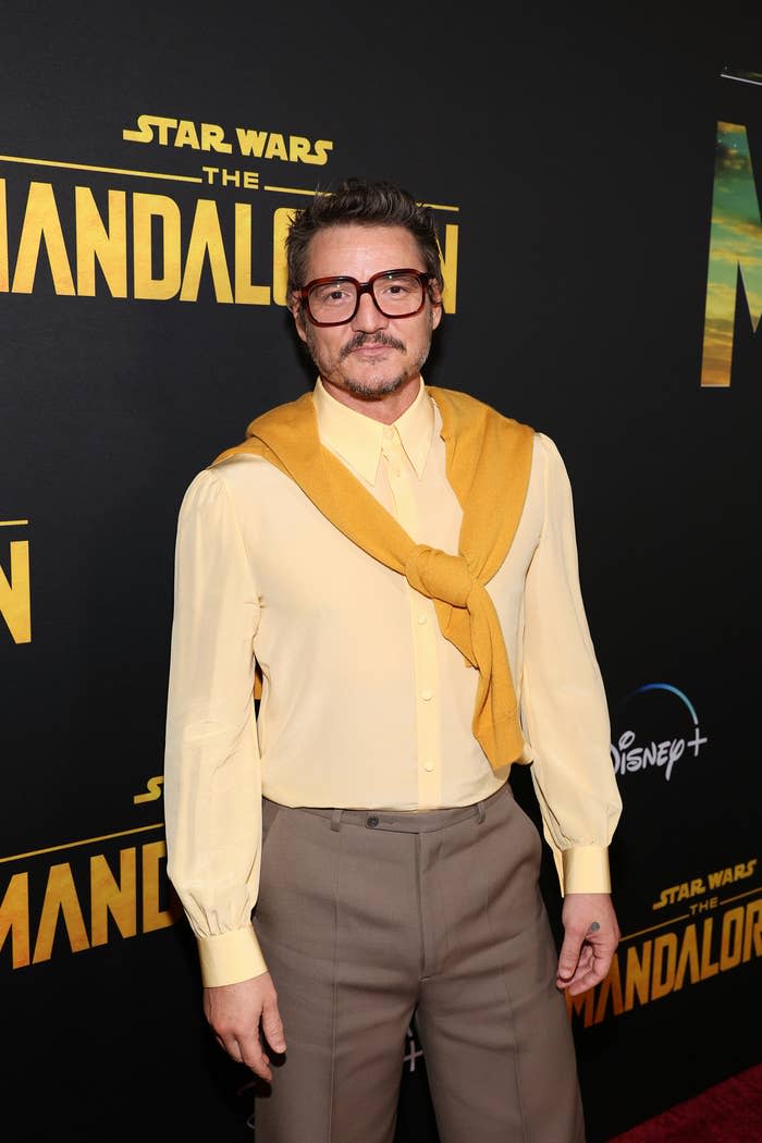 Pedro in glasses and a sweater around his neck on the red carpet