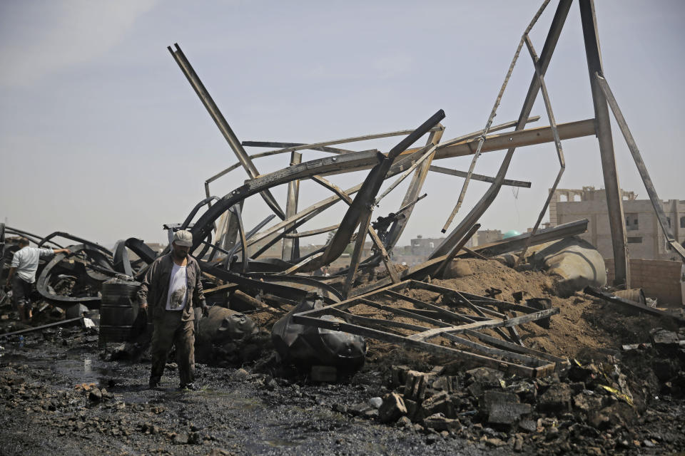 A worker walks among the wreckage of a vehicle oil store hit by Saudi-led airstrikes in Sanaa, Yemen, Thursday, July 2, 2020. (AP Photo/Hani Mohammed)