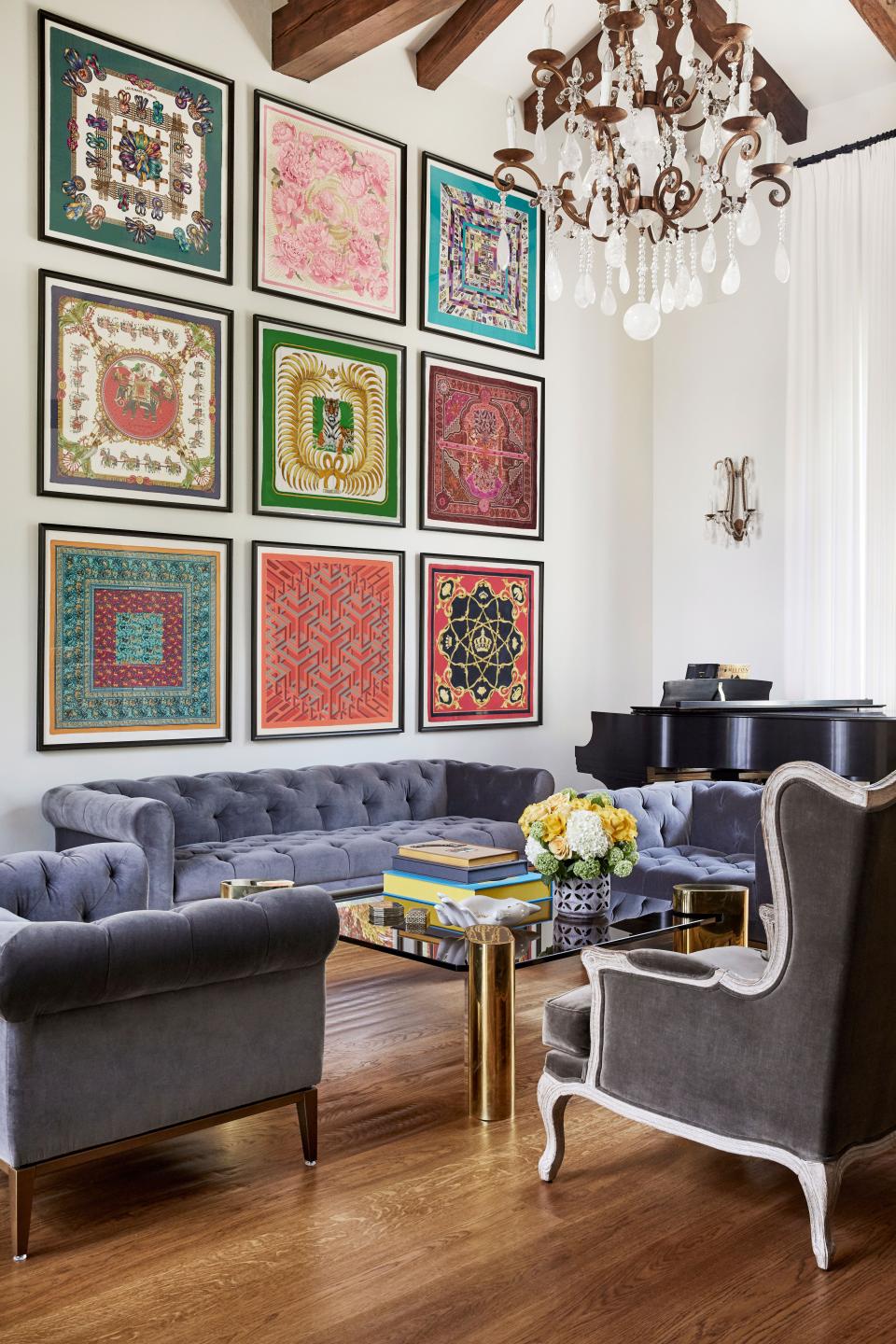 Designer Reza Farahan utilized the living room’s substantial height by positioning a grid of nine vintage Hermès scarves above the RH couch. The coffee table is a vintage Karl Springer made out of brass and smoked glass. Farahan custom-designed the rock crystal chandelier and sconces.