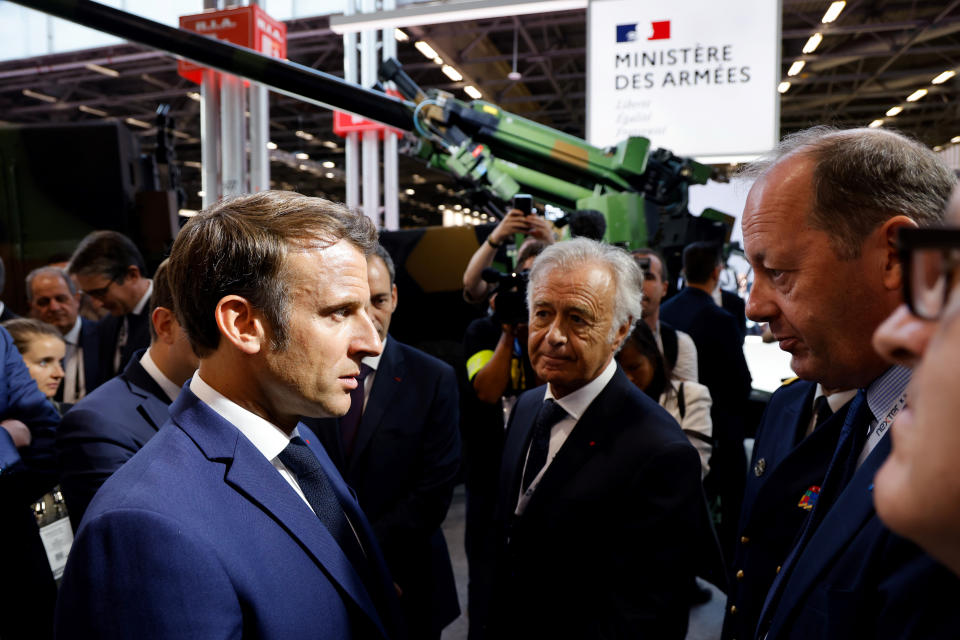 FILE - French President Emmanuel Macron, left, speaks with arms industrialists near a CAESAR self-propelled howitzer artillery system s they visit the Eurosatory land and airland defense and security trade fair, at the Paris-Nord Villepinte Exhibition Centre in Villepinte, north of Paris, Monday, June 13, 2022. (Ludovic Marin, Pool via AP, File)