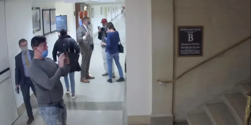 A man who made threatening statements towards Democratic lawmakers outside the Capitol on January 6 photographs a basement stairwell in Longworth House Office Building as Rep. Barry Loudermilk led him on a tour on January 5, 2021.