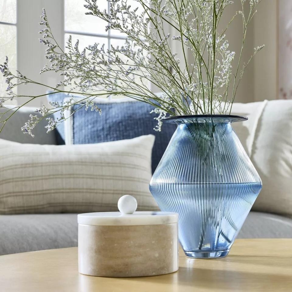 A textured glass vase with flowers on a table