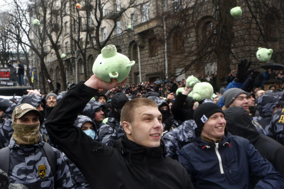 Far-right demonstrators throw toy pigs and shout "Poroshenko's pigs to jail" during a rally against corruption in front of the Presidential administration's building in Kiev, Ukraine, Saturday, March 16, 2019. (AP Photo/Efrem Lukatsky)
