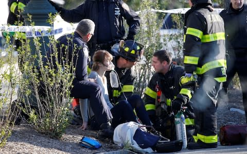 A woman is aided by first responders after sustaining injury on a bike path in lower Manhattan in New York - Credit: REUTERS/Brendan McDermid