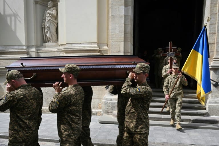 Soldados ucranianos portan a hombros el féretro de un camarada muerto durante un funeral en la ciudad de Leópolis, el 2 de mayo de 2024 al oeste de Ucrania (Yuriy Dyachyshyn)