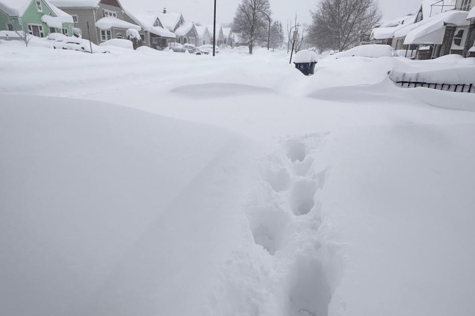 Footprints appear on a residential street after at least 18 inches of new snow fell overnight - on top of the three feet that arrived over the weekend in Buffalo, N.Y., Wednesday, Jan. 17, 2024. (AP Photo/Carolyn Thompson)