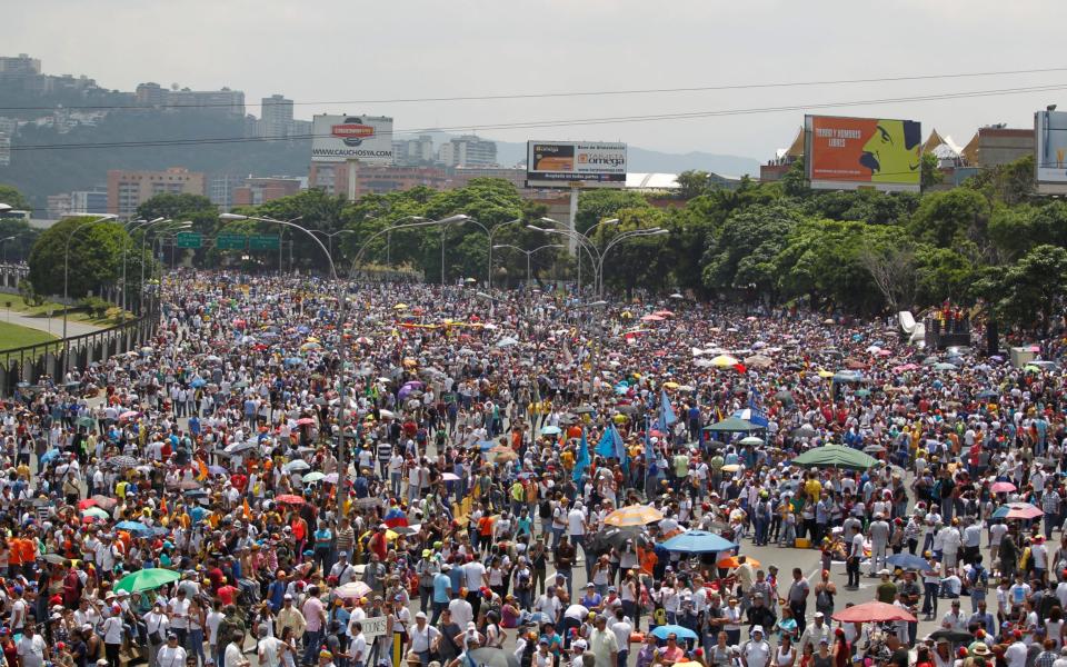 Opposition supporters attend a rally against Nicolas Maduro in Caracas - Credit: Reuters