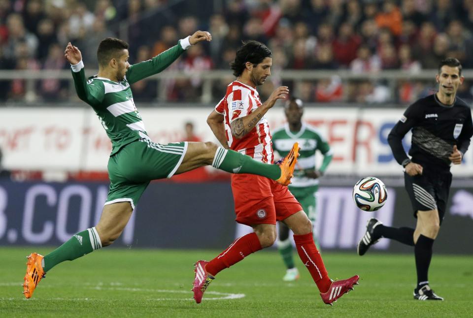 Olympiakos' Alejandro Dominguez, right, and Panathinaikos' Mehdi Abeid run for the ball during a Greek League soccer match at Georgios Karaiskakis stadium, in Piraeus port, near Athens, on Sunday, March 2, 2014. (AP Photo/Thanassis Stavrakis)