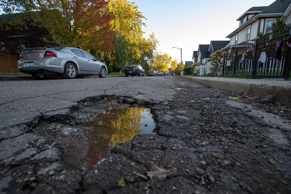 Potholes and street deterioration along Carrollton Avenue on Tuesday, Oct. 26, 2021, in the Kennedy King neighborhood of Indianapolis. 