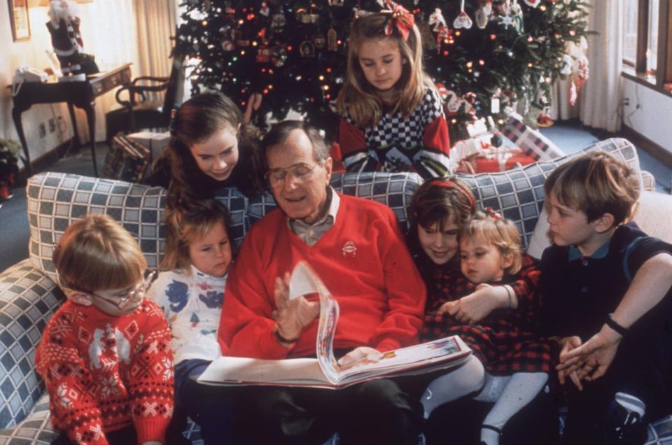 George H.W. Bush reads to his grandchildren on Christmas Eve in 1991.