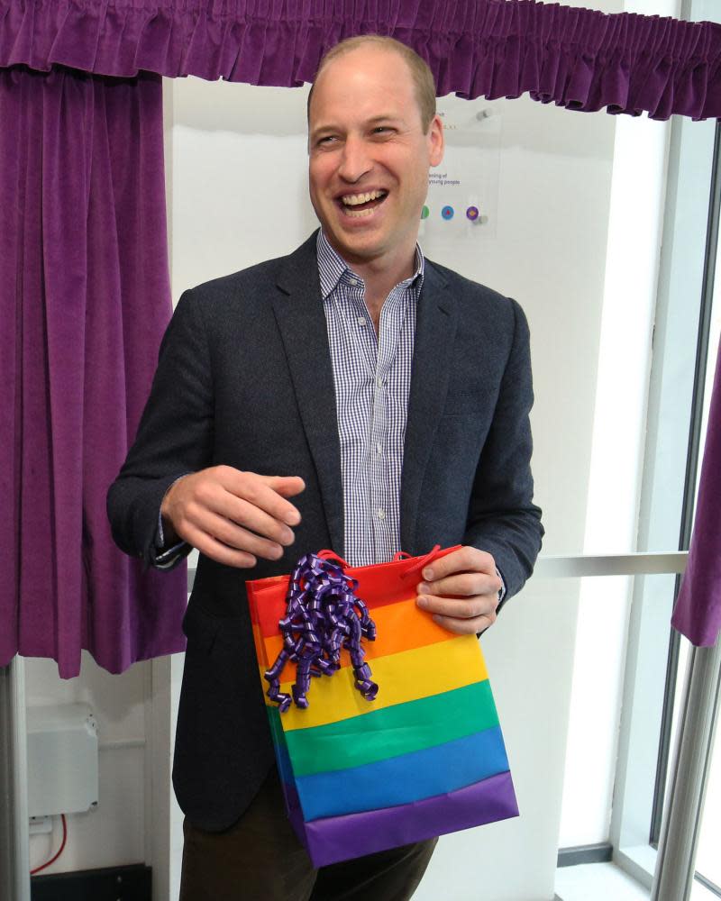 Prince William receives a gift bag during his visit to the Albert Kennedy Trust