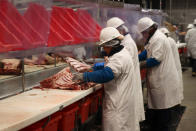 Workers carve up cuts of beef at the Greater Omaha Packing beef processing plant in Omaha, Neb., on Wednesday, Nov. 2, 2022. Greater Omaha is receiving a $20 million grant to expand its operations as part of a larger USDA program to expand meat processing capacity and encourage more competition in the highly concentrated business. (AP Photo/Josh Funk)