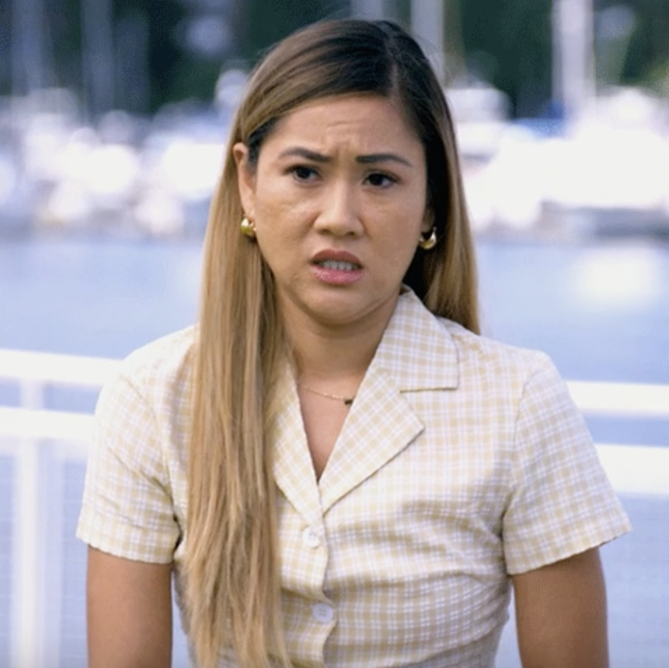 Woman in plaid shirt making a confused facial expression outdoors