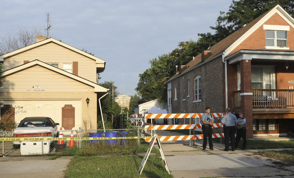 Police stand outside a property following a report that two bodies may be buried in the yard of a home in the 3900 block of Center Avenue in suburban Lyons, Ill., Friday, Aug. 27, 2021. Authorities are planning to excavate the suburban Chicago backyard Friday after two adult brothers found living in what police called a “hoarder home" said they had buried the bodies of their mother and sister there. (Antonio Perez/Chicago Tribune via AP)