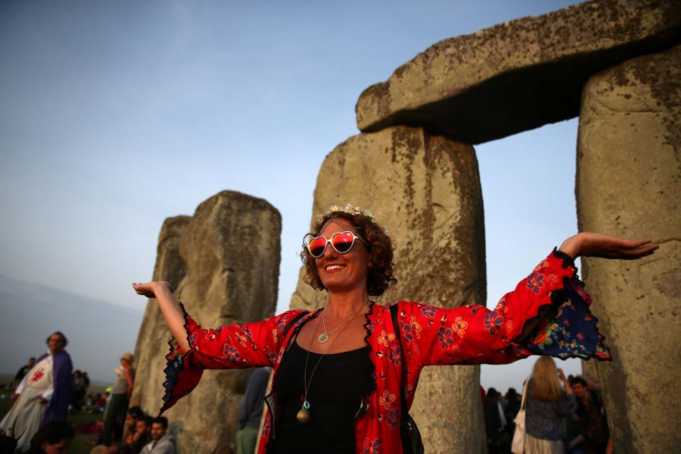 <p>A woman watches the sun rise at the stones of the Stonehenge monument on the summer solstice near Amesbury, Britain, June 21, 2017. (Photo: Neil Hall/Reuters) </p>