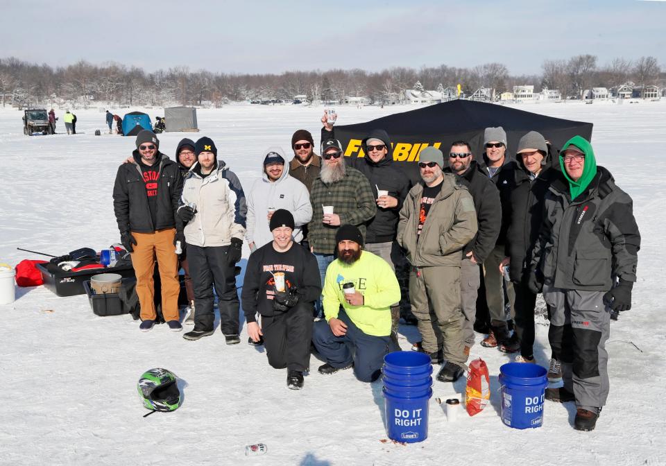 A large group of ice fishers, all with ties to the Adrian area, gather for a photo while enjoying a sunny Saturday afternoon out on Devils Lake. The 70th annual Devils and Round Lake Men's Club's Tip-Up Festival began Friday and continued through Sunday.