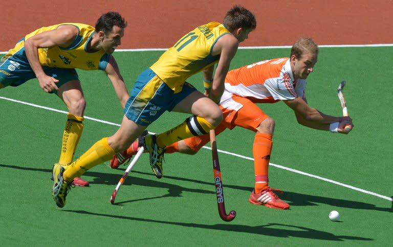 Captain Eddie Ockenden of Australia (centre) challenges Billy Baaker of the Netherlands in the gold medal match at the men's Hockey Champions Trophy tournament in Melbourne. Australia went some way to erasing the pain of their London Olympics flop by winning a record fifth consecutive Champions Trophy in a 2-1 extra-time victory over the Netherlands